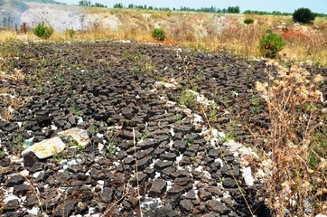 FOTO. Ed intorno alla cava fumante si trova di tutto: persino pannelli solari, sacchi di ammoniaca e bossoli di fucile