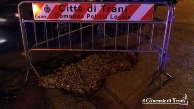 Transenne intorno all'enorme buca di via Città di Milano: nessuna manutenzione da quando il tratto finale è stato aperto al traffico
