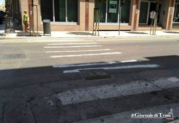 Strisce pedonali cancellate, è momento del «fai da te»: cittadina all'opera, a mano libera, sul corso di Trani