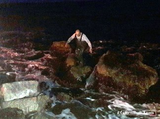 In acqua di sera, e fra le onde, per recuperare le transenne gettate in mare. Azione spontanea, e gratuita, di Trani soccorso