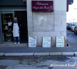 Via Marsala, fango e pietre sulla vetrina del salumiere: Trani, quando le buche non danneggiano solo le auto
